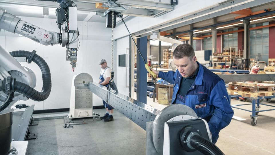 Mitarbeiter an Maschine mit großem Teil
