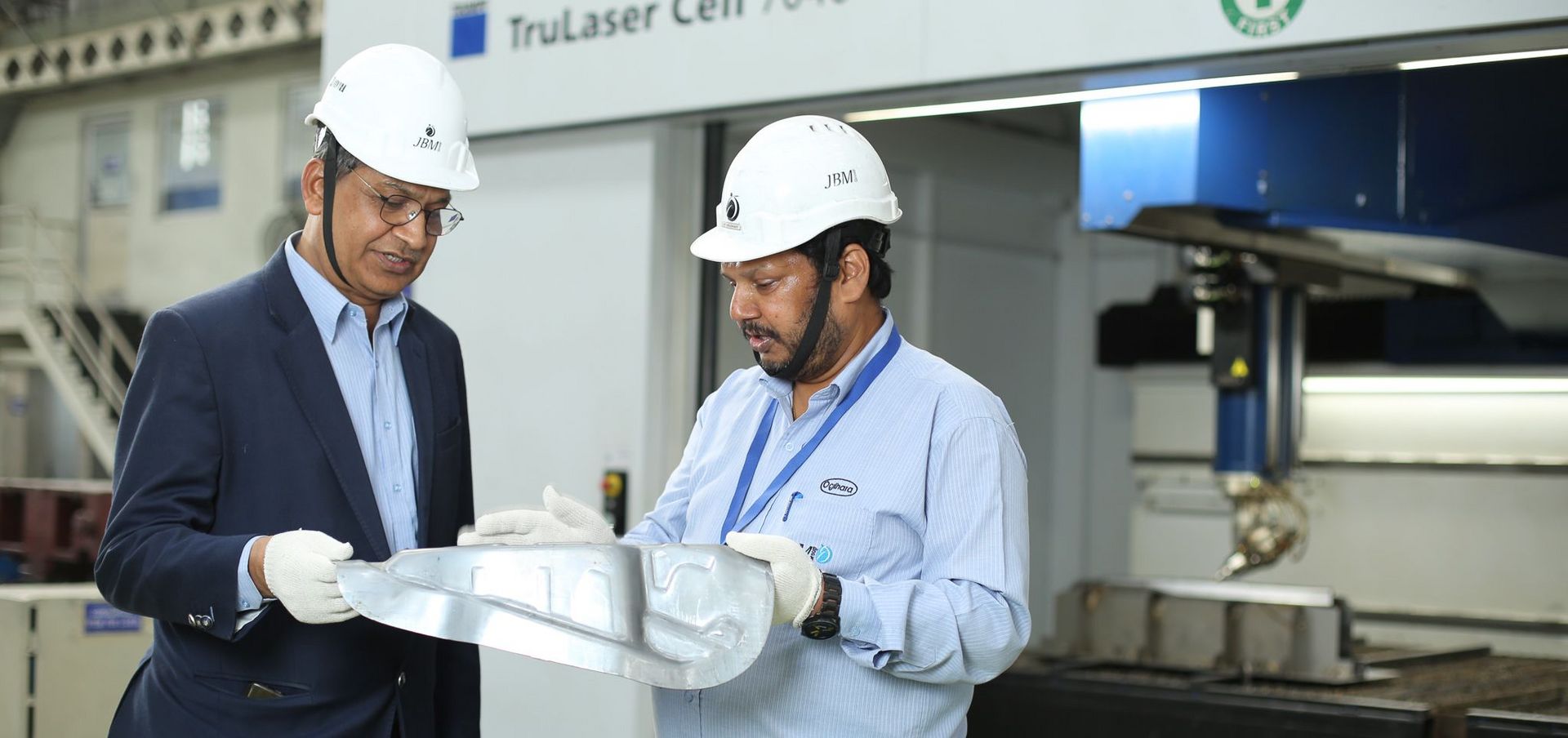B. B. Gupta (links), Präsident Strategy & Business Planning von JBM Auto Components, und General Manager Ajit Choudhary inspizieren Bauteile, die mit der TruLaser Cell 7040 beschnitten wurden. 