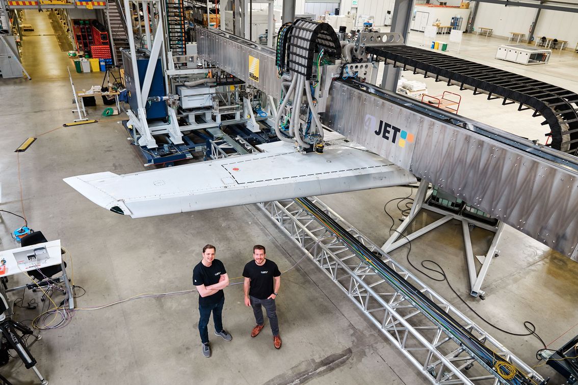 Flugzeugflügel-Prüfstand mit zwei Technikern in der Halle