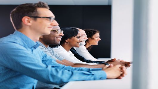 Sıra halinde oturmuş gülüşen TRUMPF çalışanları