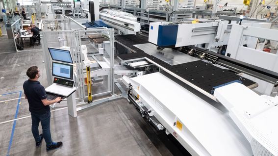 Techniker bedient CNC-Stanzmaschine in einer Fabrikhalle in Österreich