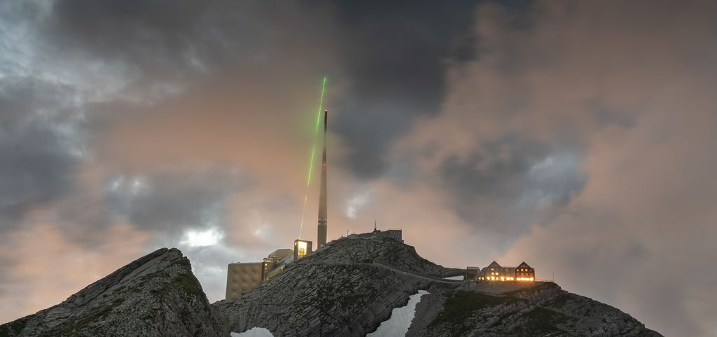 Grüner Laser auf Bergspitze