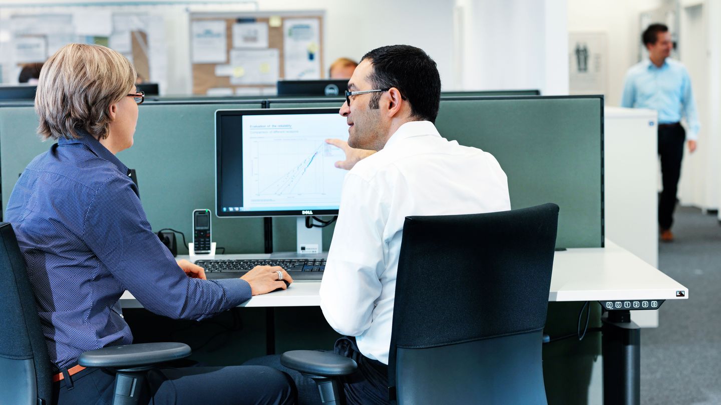 TRUMPF employees sitting on a desk and working with DMAIC improvement cycle as a core tool used to drive Six Sigma projects