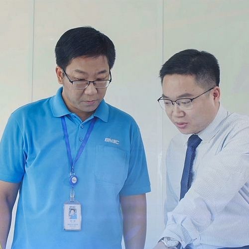 Kollegen vor einem Miniaturmodell der Produktion